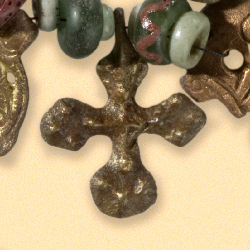 Ortodoks bronsekors-anheng, detalj fra smykke. Korset har i moderne tid blitt kopiert i sølv og gull, av NC Christophersen som en del av deres smykkeserie «SAGA». Smykket ligger lagret hos Kulturhistorisk Museum, UiO i Oslo. Museumsnummer C5456.